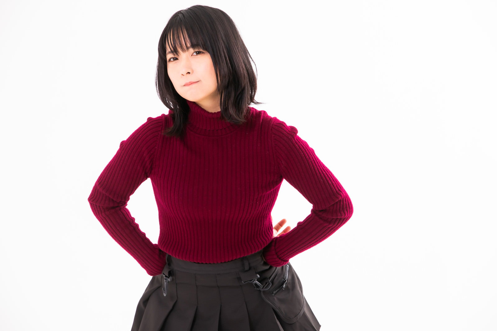 Woman in red sweater with hands on hips and displeased expression