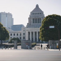 車道越しに見た国会議事堂のドーム屋根と都市景観の写真