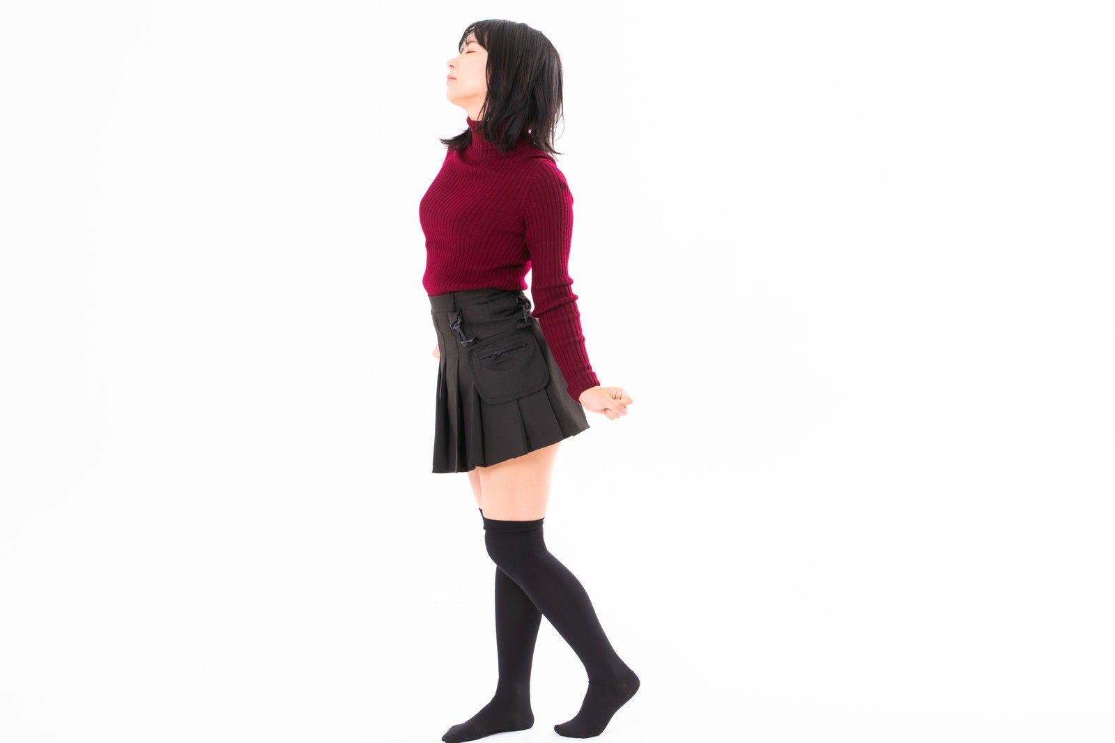 赤いニットを着て両手を上げて伸びをする女性［モデル：にゃるる］