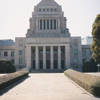 曇り空の下に立つ国会議事堂の正面風景と政治機能の象徴の写真