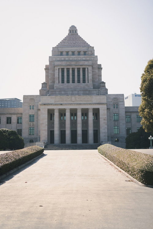 曇り空の下に立つ国会議事堂の正面風景と政治機能の象徴