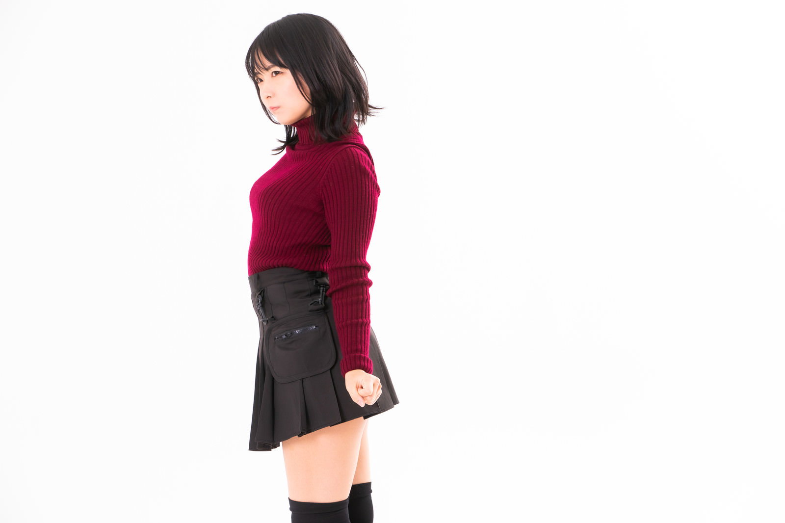 赤いトップスとグレーのスカートを着た女性が振り返るポーズ［モデル：にゃるる］