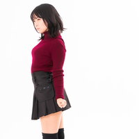 赤いトップスを着てポージングを決める女性の横顔の写真