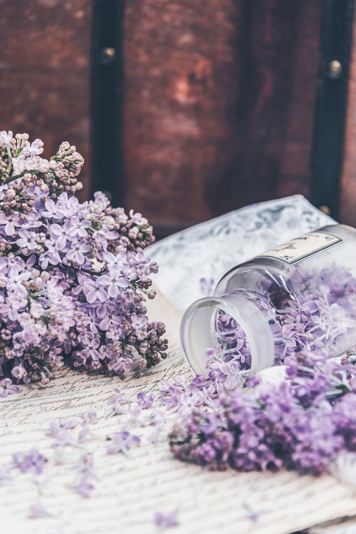 手紙にこぼれるライラックの花と透明なボトル