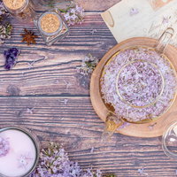 ライラックの花を添えたティーセットと木製テーブルの写真