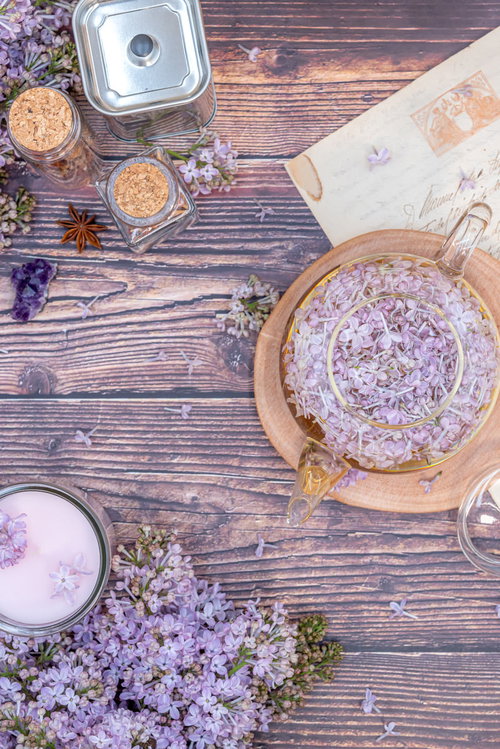 ライラックの花を添えたティーセットと木製テーブル