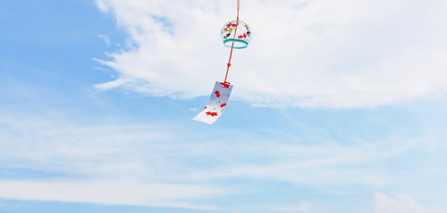 涼を味わう日本の夏、青空に吊るされた赤い風鈴