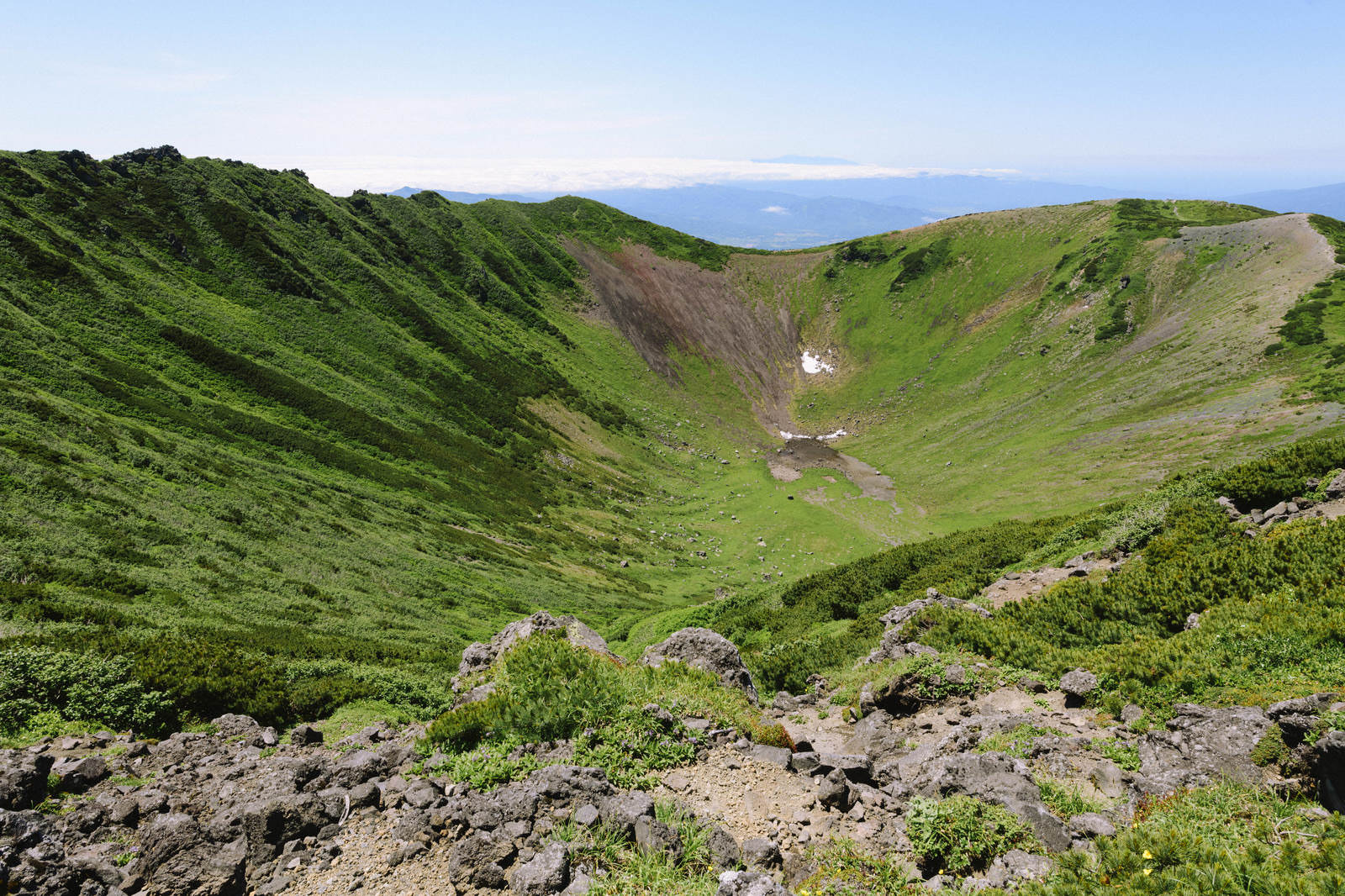 後志羊蹄山の火口・父釜。緑の火口壁に白い雪渓がある