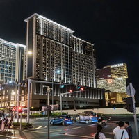 夜間にライトアップされたマカオのホテル群と観光客の町並みの写真