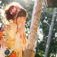 初詣で鈴を鳴らして参拝する着物女子の成人式振袖姿の写真