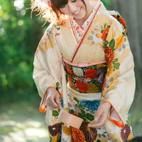 神社の手水舎で清めの儀式をする振袖姿の着物女性の写真