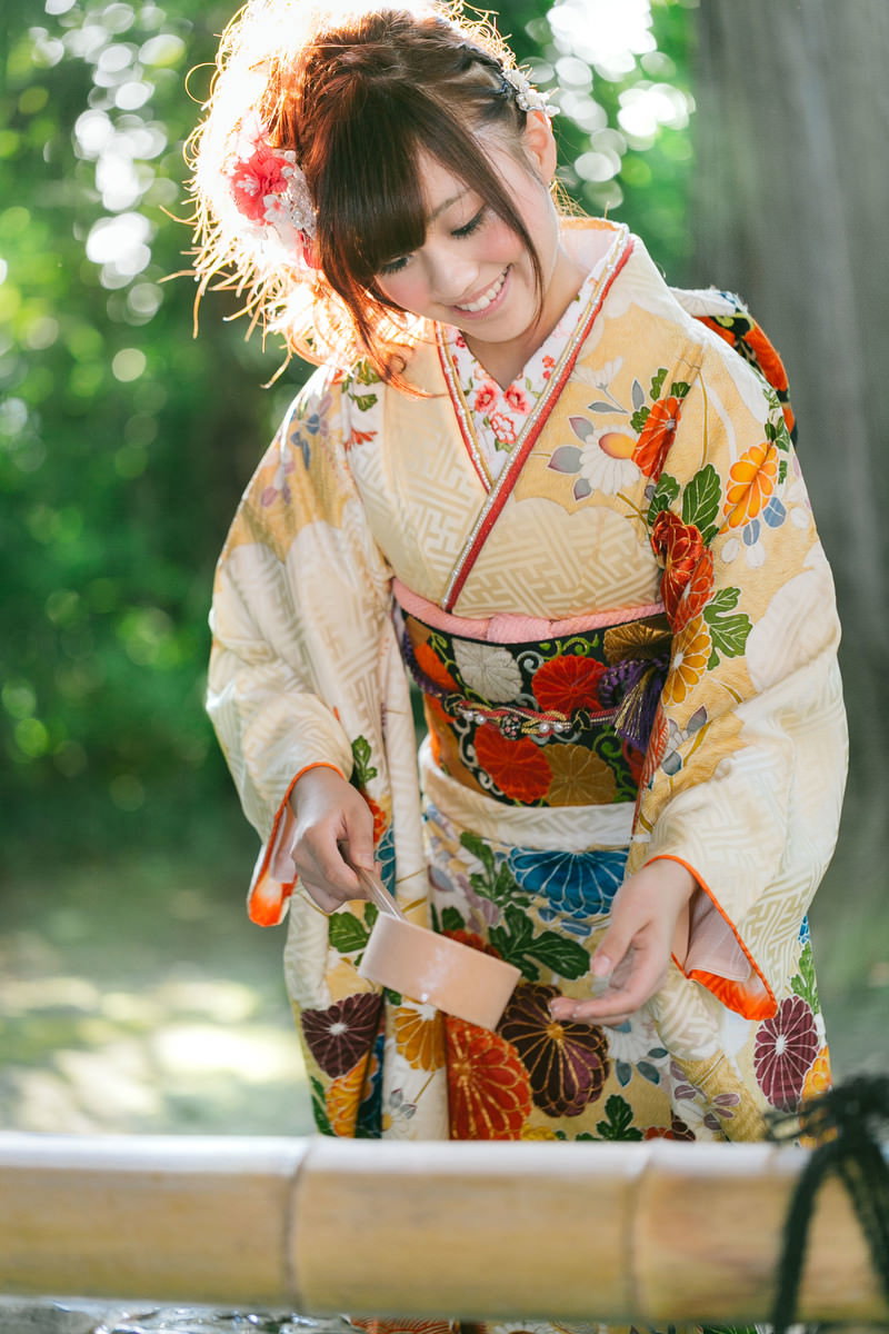 神社の手水舎で清めを行う色鮮やかな振袖姿の女性［モデル：河村友歌］