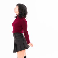 胸を張って伸びをする赤いトップスの女性のストレッチポーズの写真