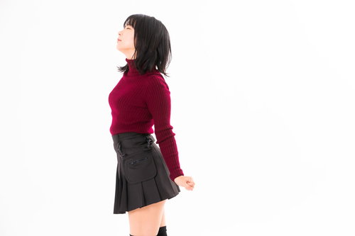 胸を張って伸びをする赤いトップスの女性のストレッチポーズ