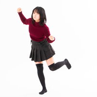 我慢の限界で右手の拳を振り上げる怒りの女性の写真