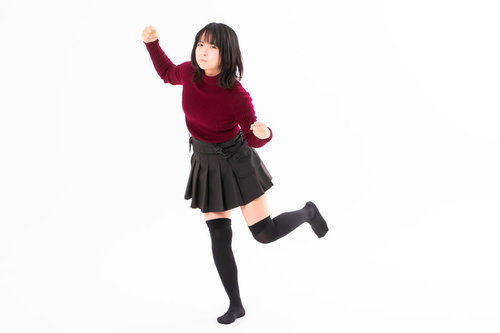 我慢の限界で右手の拳を振り上げる怒りの女性