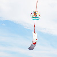 涼を感じる夏の風物詩、赤紐に吊るされた風鈴の音色の写真