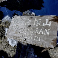 雪に埋もれて倒れた日光白根山の山頂標の写真