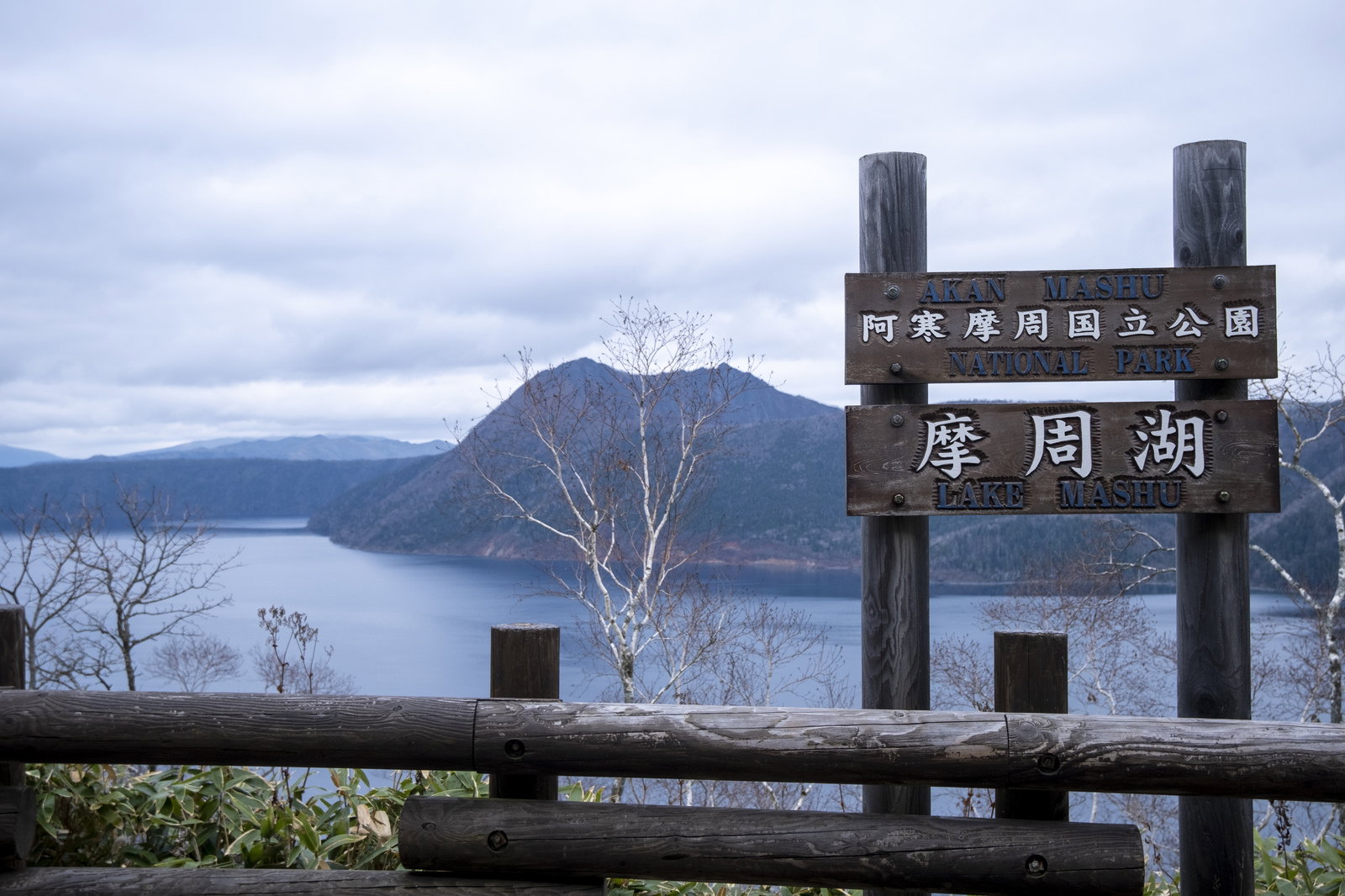 阿寒摩周国立公園の案内看板と摩周湖、カルデラの山々