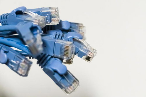 迫ってくるブルーのLANケーブル束と複数のRJ45コネクタ
