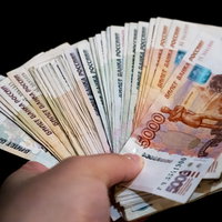 支払いはロシアルーブルでお願いします。手に持つ複数枚の紙幣の写真
