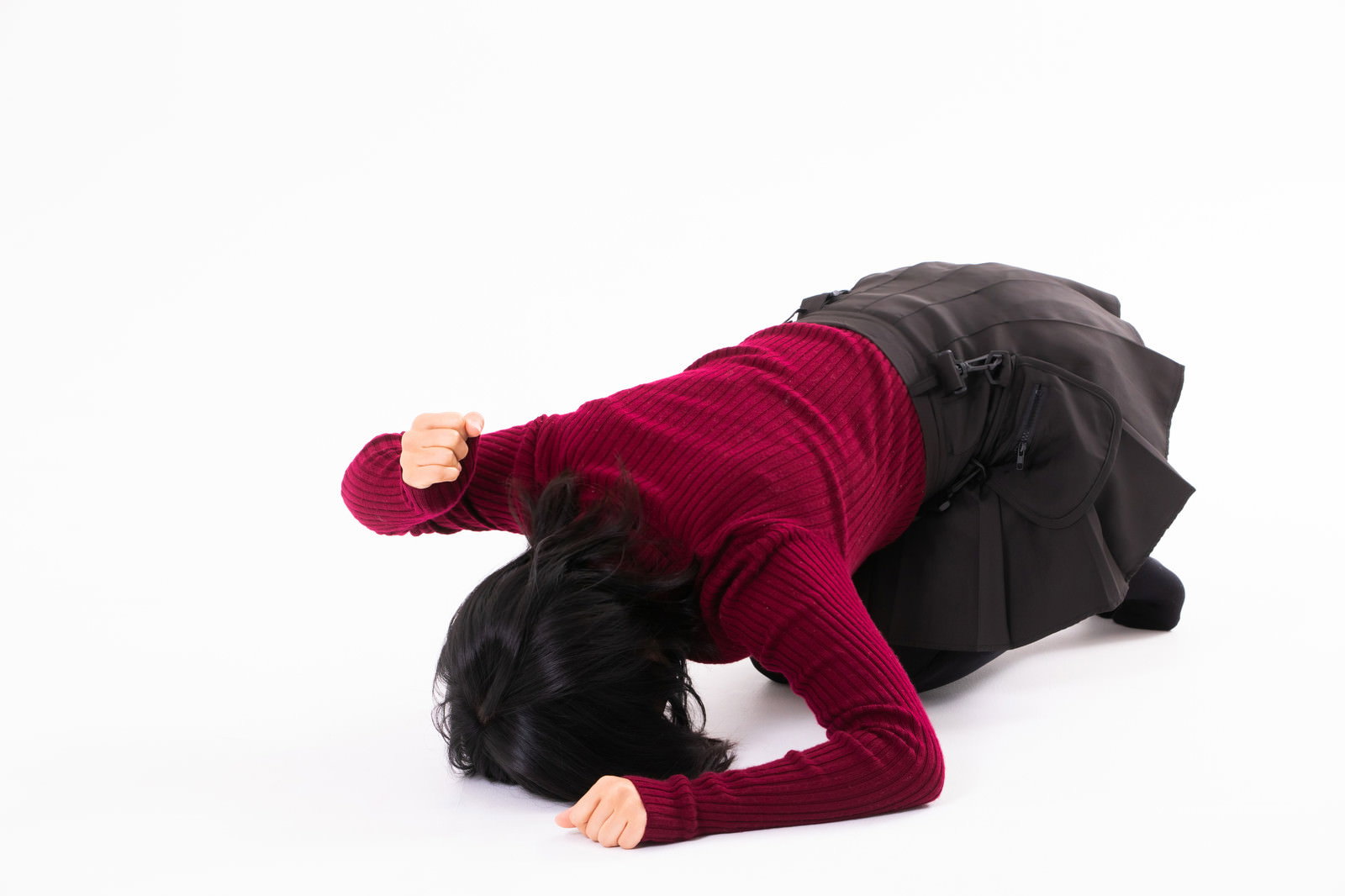 床を叩いて悔しがる赤いトップスを着た女性［モデル：にゃるる］