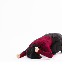 赤い服を着て床をドンドンと叩いて悔しがる女性の写真