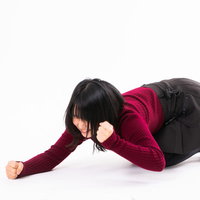 負けが悔しくて床を叩く赤い服の女性のポーズの写真