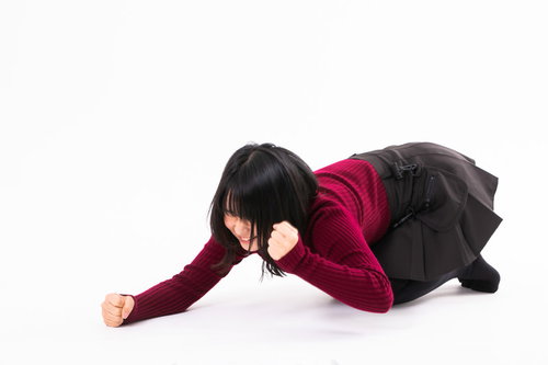 負けが悔しくて床を叩く赤い服の女性のポーズ
