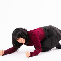 赤いトップスを着て床に両手を打ち付けて悔しがる女性の写真