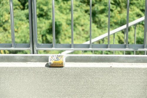 バルコニーの手すりに置かれたビール缶の