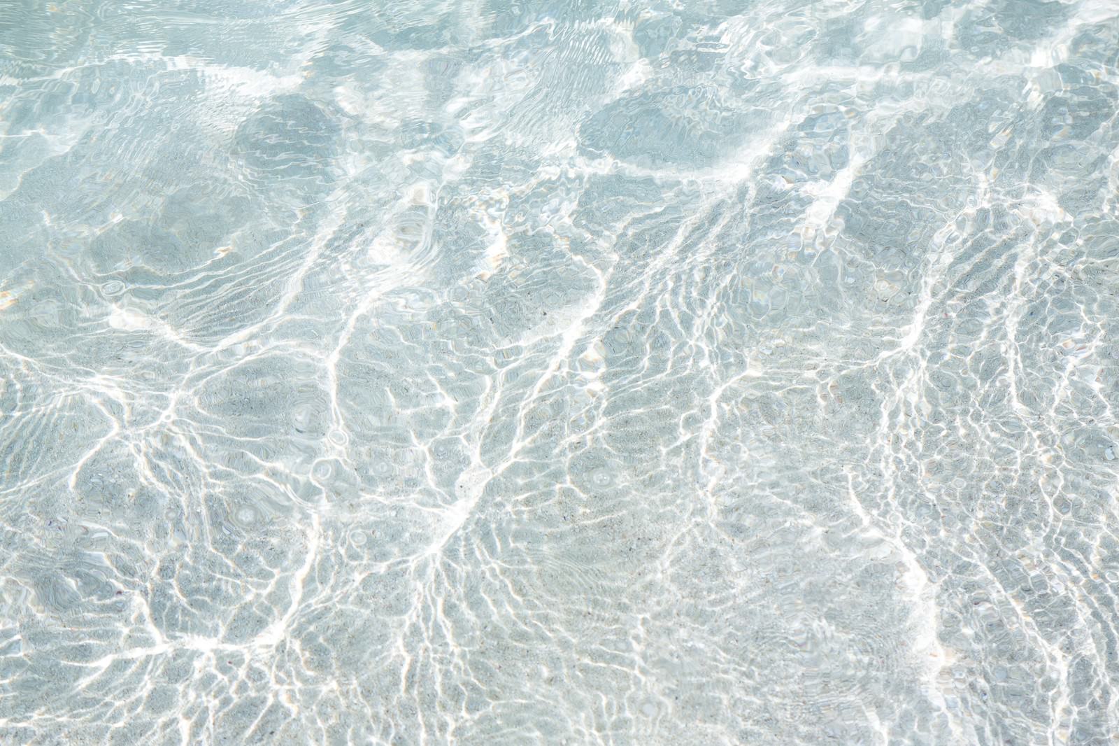 浅瀬の透き通った水面に波紋が映る様子