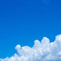 快晴の青空に浮かぶ大きな入道雲と積雲の風景の写真