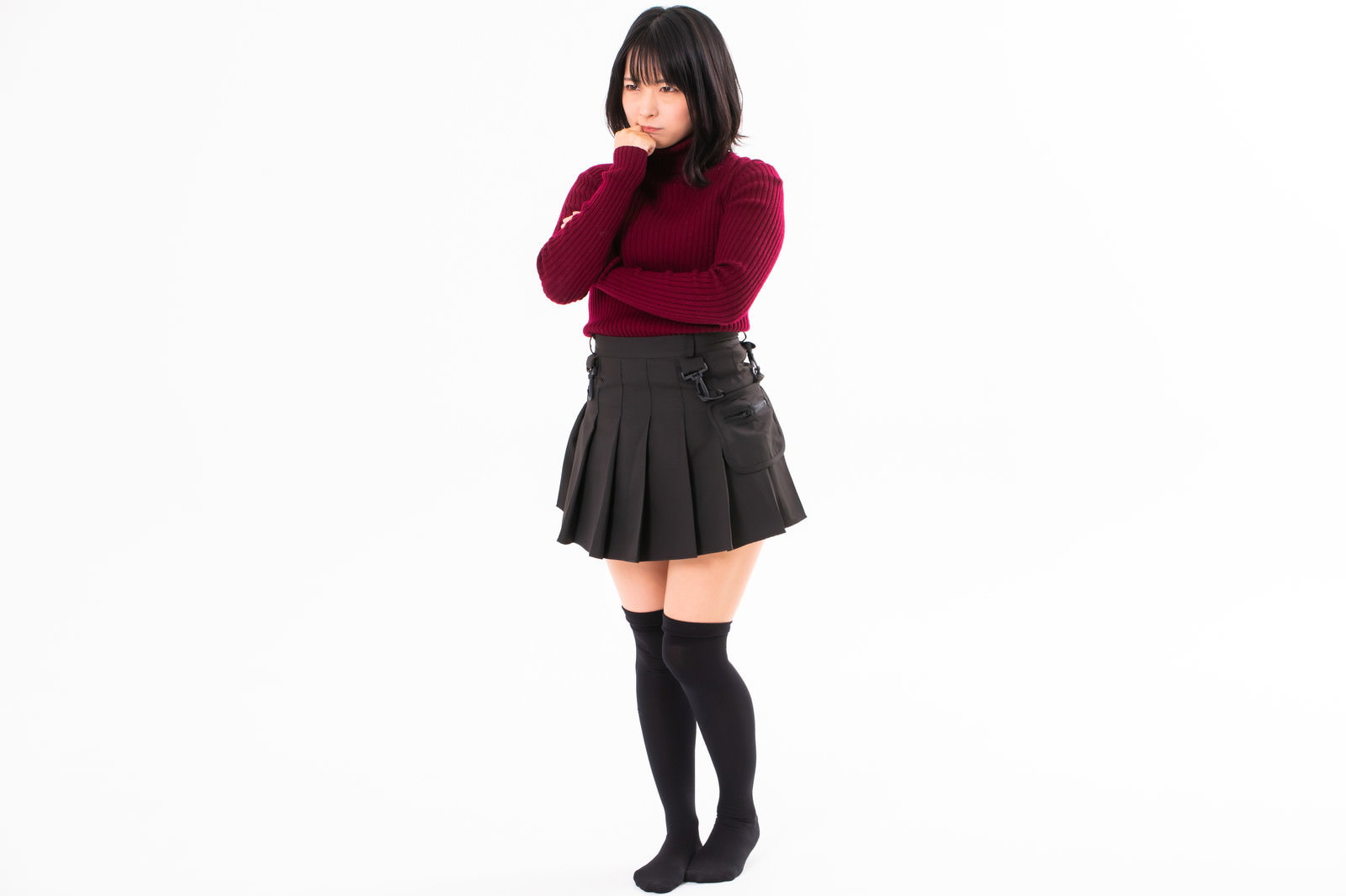 顎に手を当てて考えるポーズをとる女性［モデル：にゃるる］