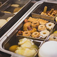 コンビニアイスクリームと揚げ菓子が並ぶセルフサービスのショーケースの写真