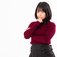 顎に手を当てて考える赤いセーターの女性のポーズの写真