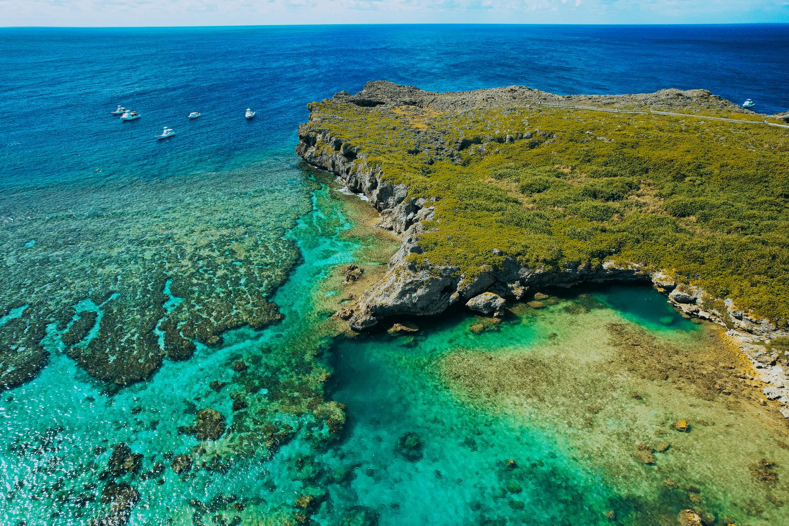 宮古島の岬とエメラルドグリーンの海に広がる珊瑚礁をドローンで空撮した風景