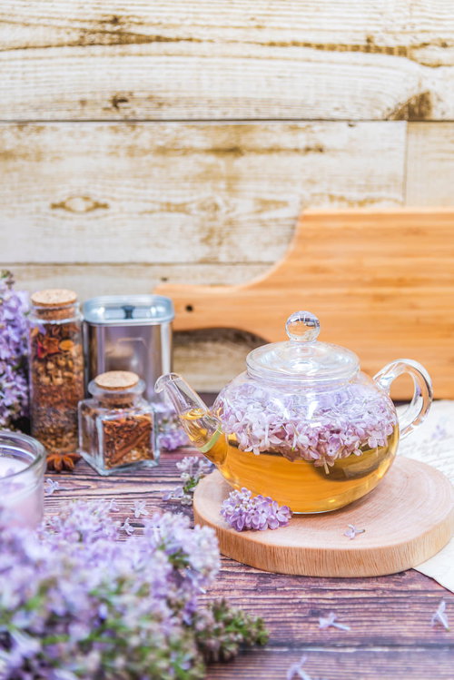 木製テーブルに置かれたライラック入りのティーポット