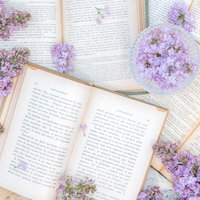 敷き詰められた古書とライラックの花、開かれたフランス語の洋書の写真