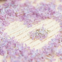 ハートの中心に輝くライラックと指輪のウェディングの写真