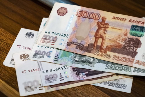 木製テーブルに無造作に置かれたロシアルーブルの紙幣