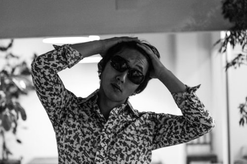 楽屋で髪をセットするチンピラ風の男性のモノクロ