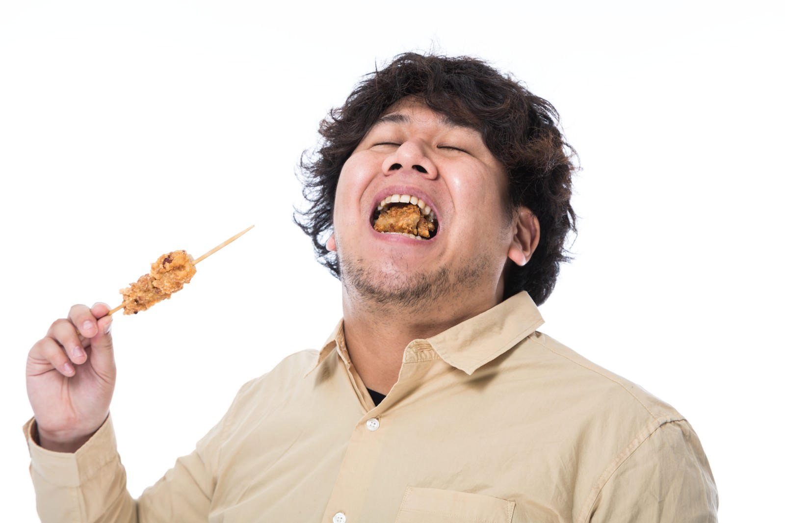 から揚げを食べて歓喜する男性［モデル：あまのじゃく］