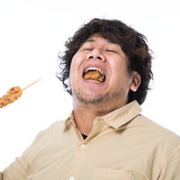から揚げを食べて歓喜する大型巨漢男性の満足した表情の写真