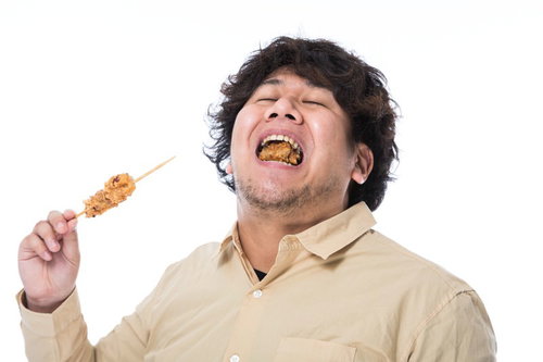 から揚げを食べて歓喜する大型巨漢男性の満足した表情