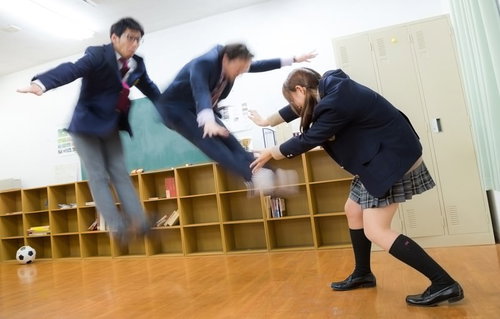 エネルギー波を繰り出す女子高生と吹き飛ぶ男子生徒