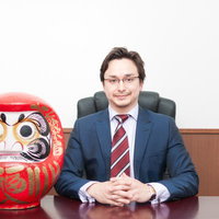 生徒会長に立候補した交換留学生と赤い達磨の写真