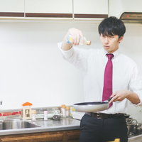 男の料理は高い位置からオリーブオイルをたらす仕草の写真