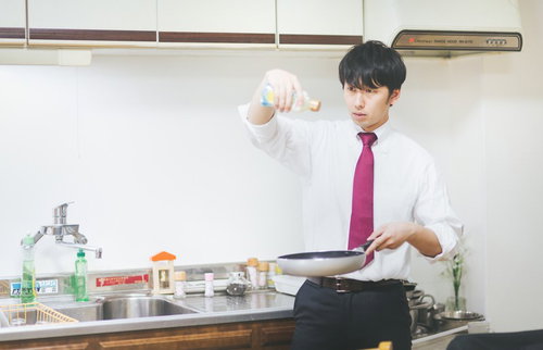 男の料理は高い位置からオリーブオイルをたらす仕草