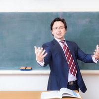 学級崩壊に癇癪を起こし両手を広げて叫ぶ男性講師の写真